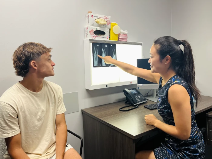 Hand Therapy Experts CHen Li Talking To A Patient Through Their Xray